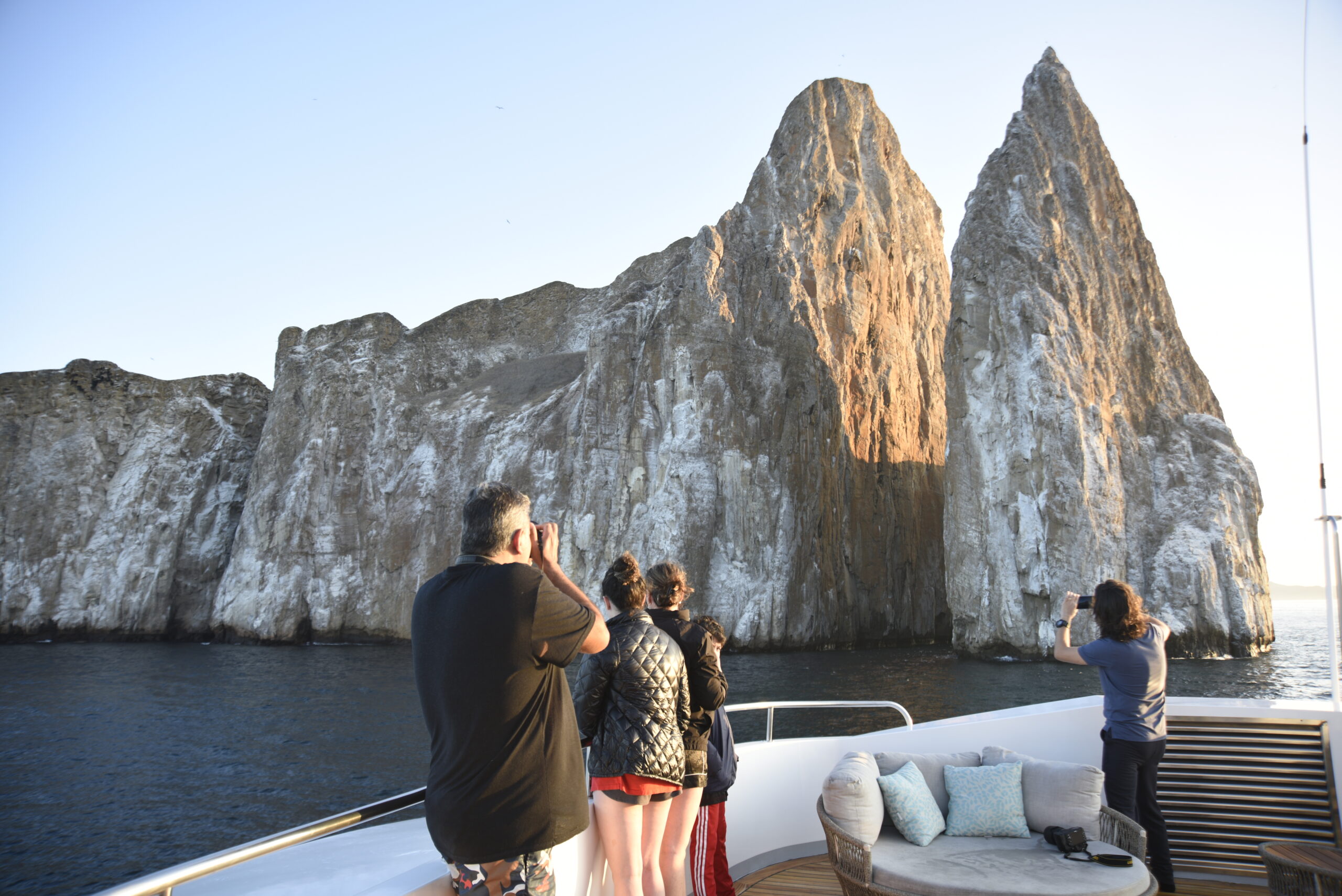 Travelers aboard a boat facing Kicker Rock in the Galapagos