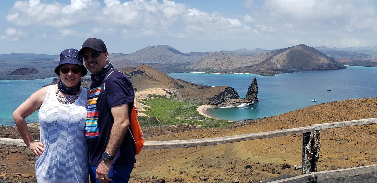 Travelers at a viewpoint overlooking Bartolome Island and Pinnacle Rock