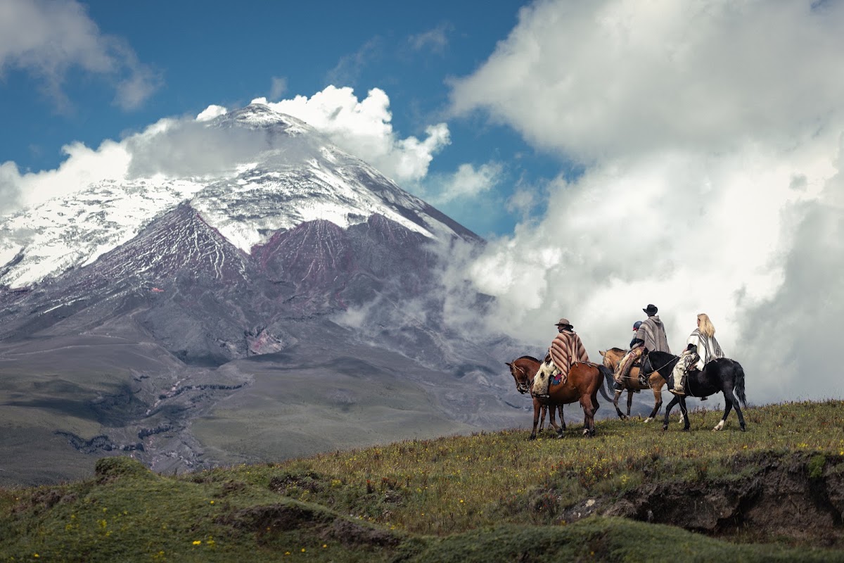 Horseback riders in the highlands beneath Cotopaxi